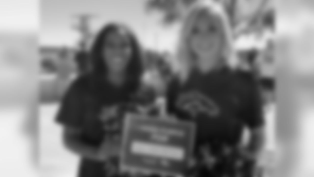 Two Broncos cheerleaders hold up a sign at Alzheimer's Awareness Day during training camp at UCHealth Training Center in Centennial, CO, August 4, 2018.
Photo by Gabriel Christus