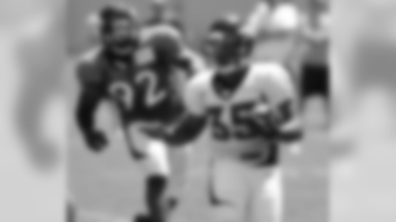 RB Lance Ball is pursued by DE Elvis Dumervil.