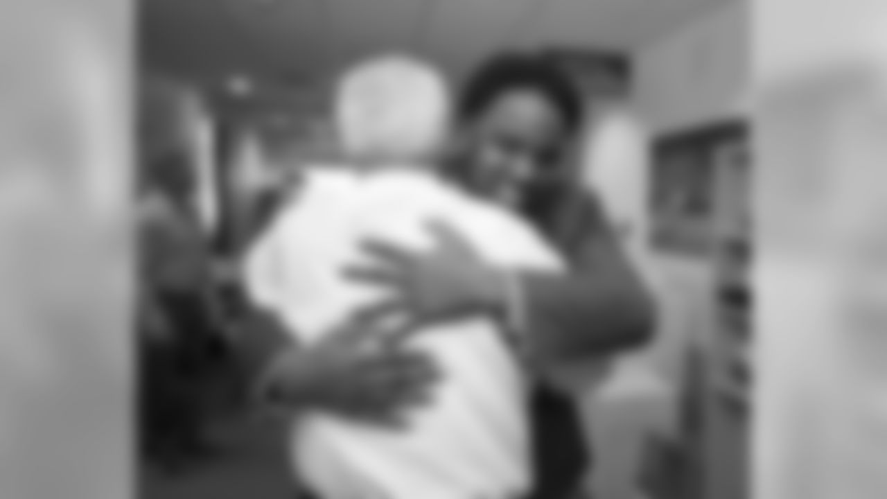 Williams and Head Coach John Fox share a hug as they meet.