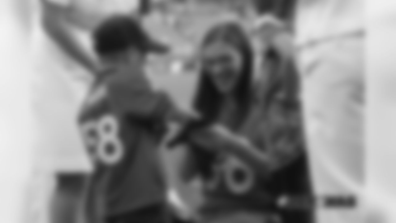 A young fan shows off the gloves a player gave him pregame before the Broncos' preseason game against the Washington Redskins at FedExField on August 24, 2018.