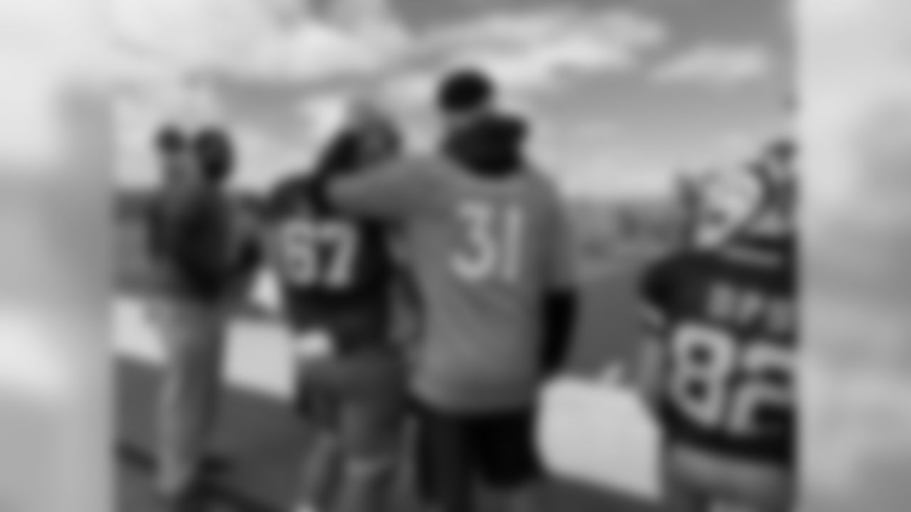 Justin Simmons puts his head on the helmet of a student on the sideline of a Futures Football game.