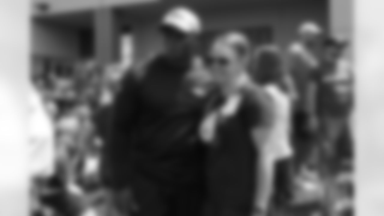 Head Coach Vance Joseph takes a photo with a hospital representative from Children's Hospital Colorado's burn unit after the final day of OTAs on June 7, 2018 at UCHealth Training Center.