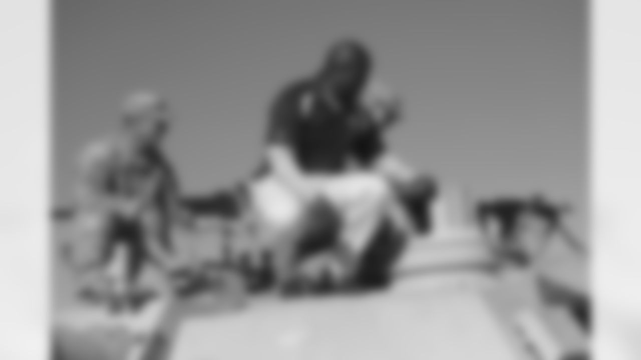 Rivers crouches atop a tank.