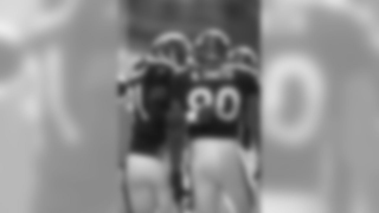Alfred Williams talks with Neil Smith as the team heads into the locker room against the New York Jets at Mile High Stadium in Denver, CO on October 3, 1999.