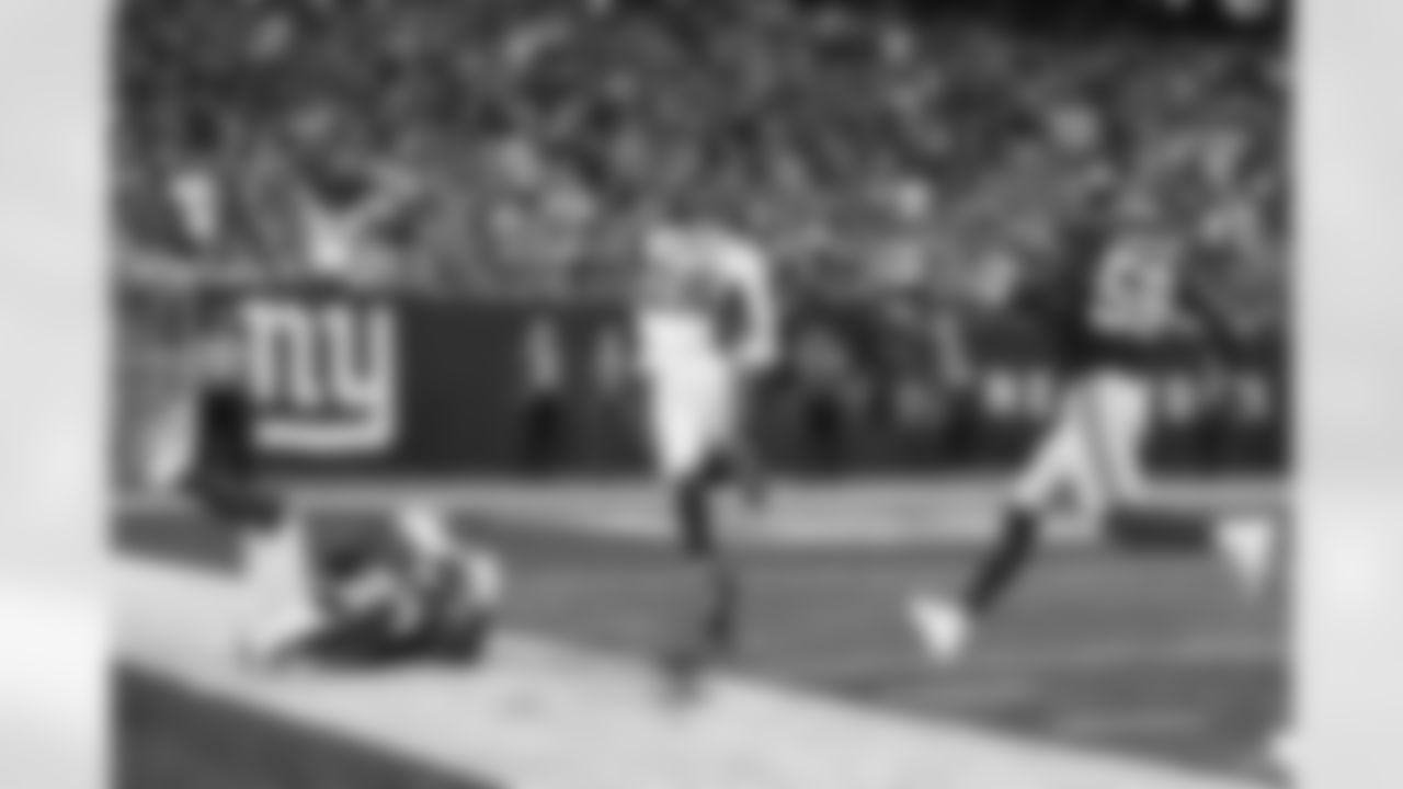 Denver Broncos running back Melvin Gordon (25) runs past New York Giants' Adoree' Jackson (22) and Lorenzo Carter (59) for a touchdown during the second half of an NFL football game Sunday, Sept. 12, 2021, in East Rutherford, N.J. The Broncos won 27-13. (AP Photo/Adam Hunger)