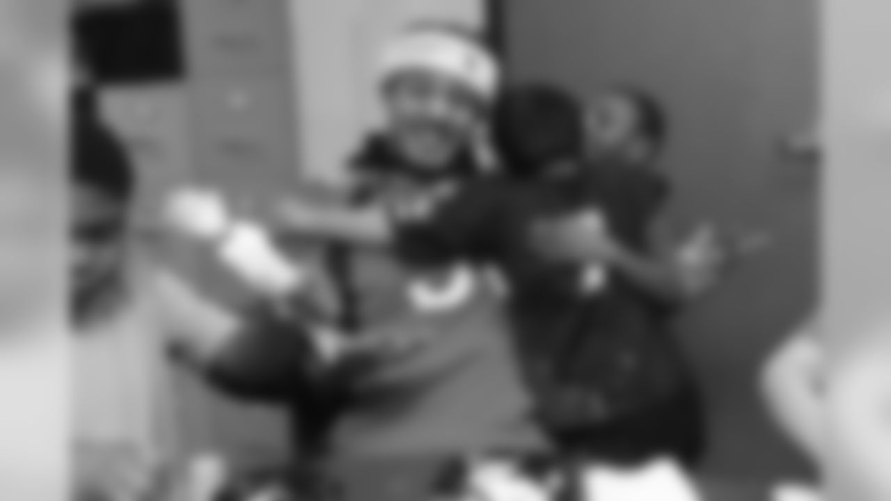 Shane Ray receives a hug from two boys at the Denver Rescue Mission's 19th annual holiday party.