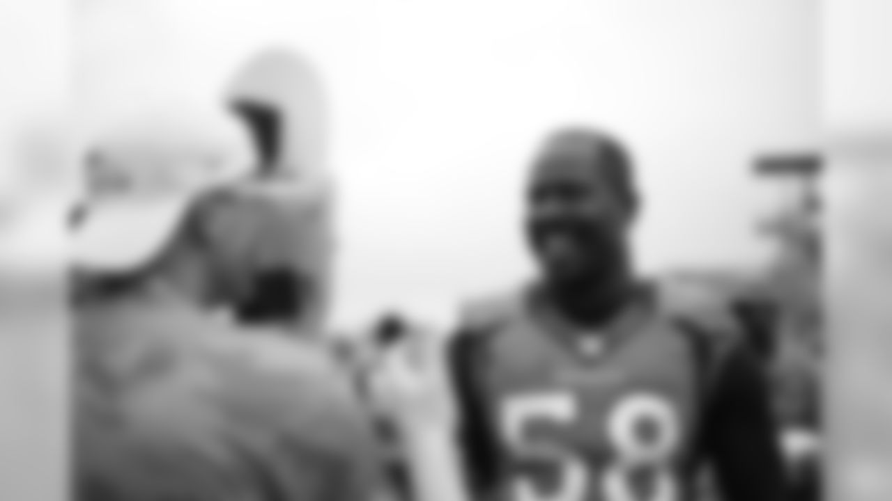Von Miller laughs as he meets a fan wearing a mask with his face on it as he signs autographs for military members from the USAA Salute to Service NFL Boot Camp after practice on August 21, 2019 at UCHealth Training Center.