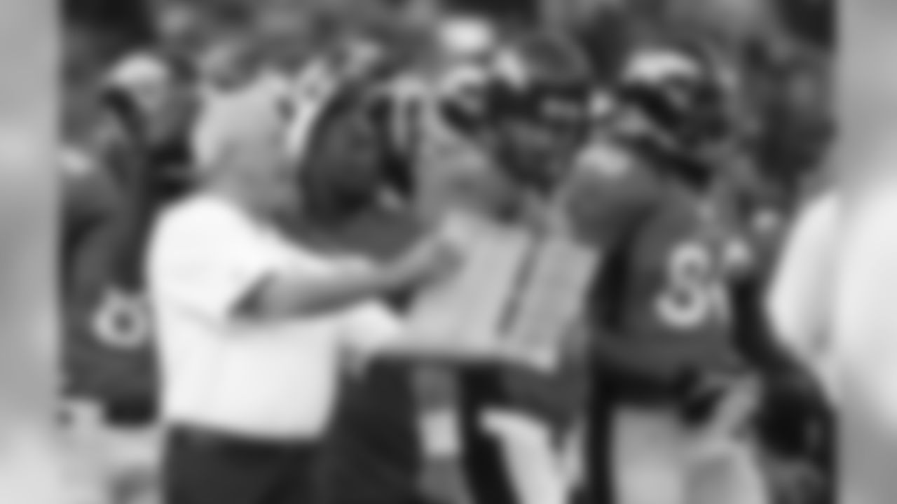Head Coach John Fox shows Manning the play before he heads onto the field.