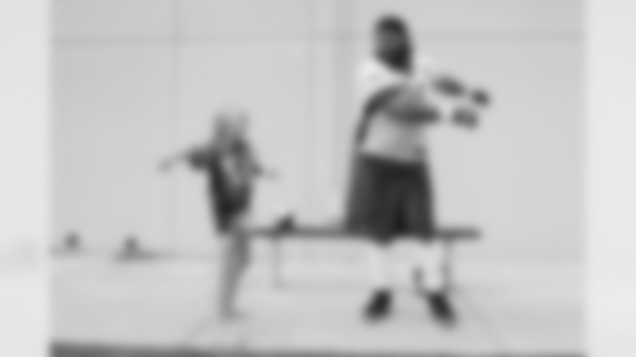 Children's Hospital Colorado junior reporter Kaylea dances with Domata Peko Sr. after practice on September 5, 2018 at UCHealth Training Center.