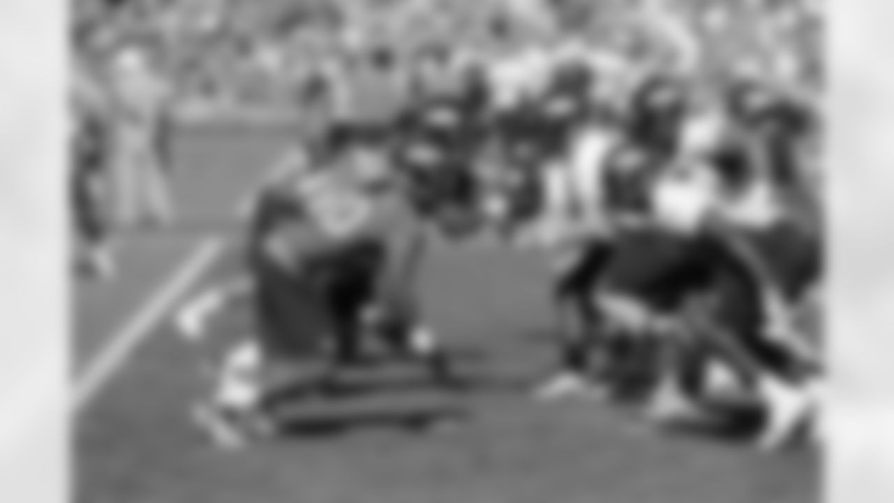 The offense and defensive linemen converge during a play.