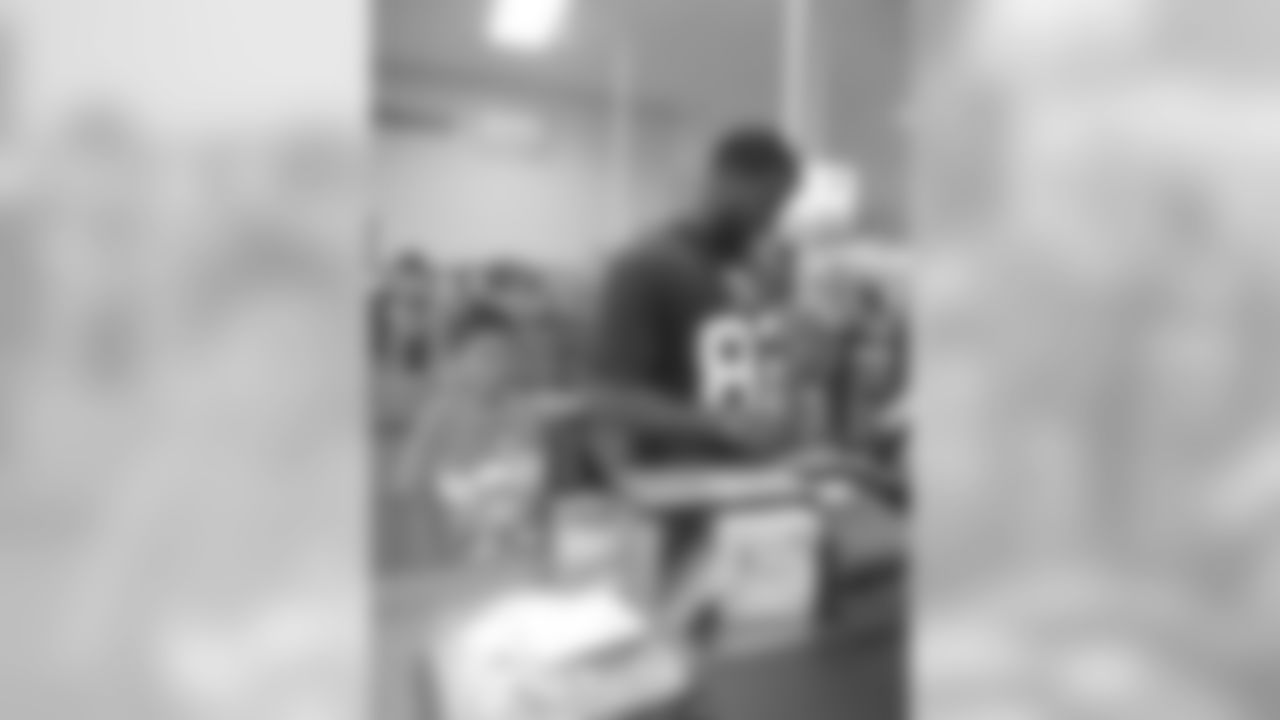 Broncos tight end Cornelius Ingram helps pay for a customer's groceries at King Soopers on June 9.