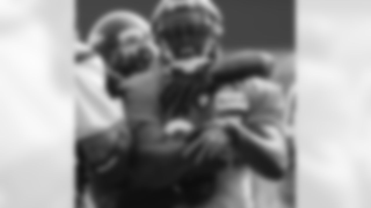 RB Willis McGahee laughs as DE Elvis Dumervil wraps him up.