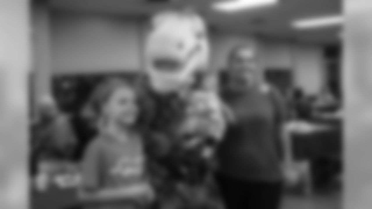 Miles the mascot poses for a photo at the Denver Rescue Mission's 19th annual holiday party.