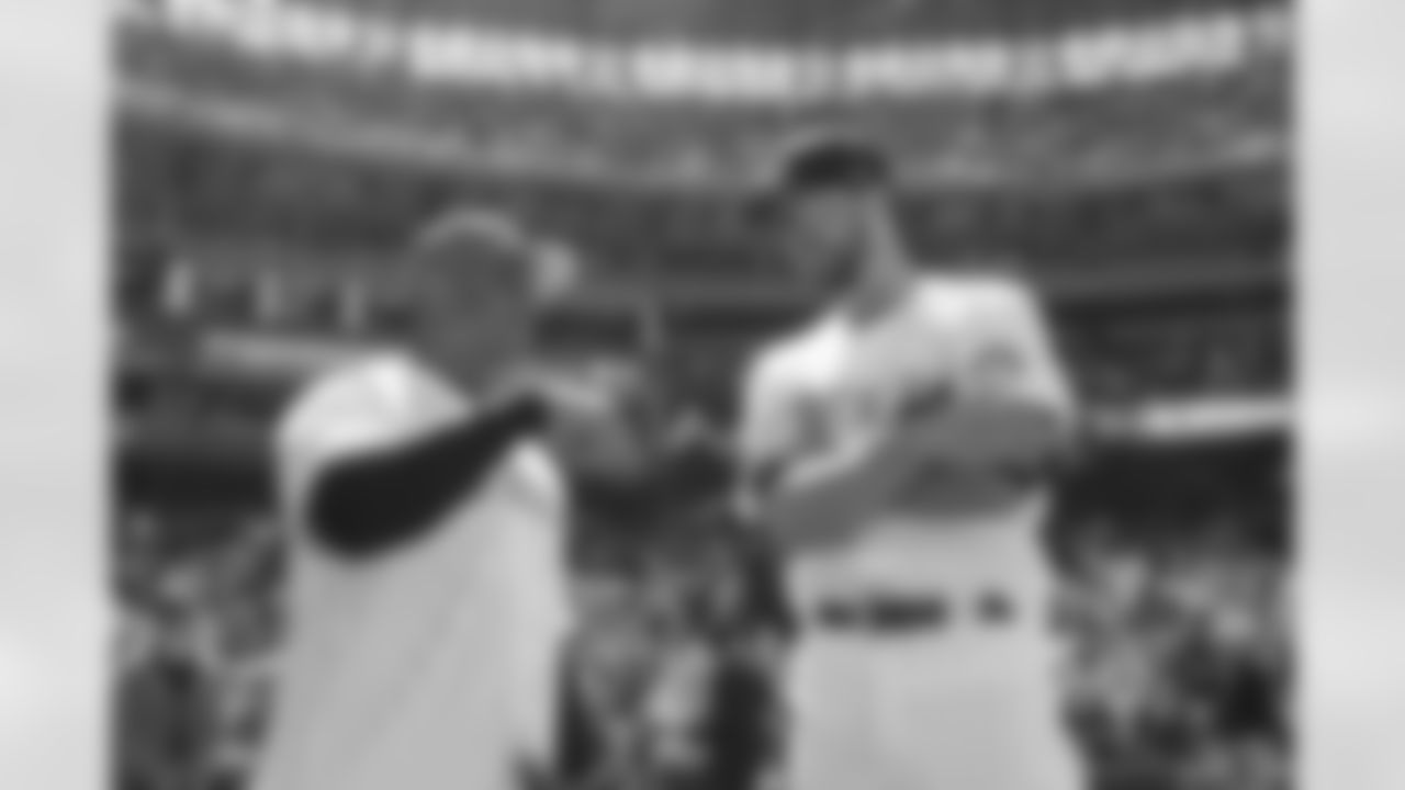 Russell Wilson talks with outfielder Kris Bryant as he prepares to throw out the first pitch during his visit to the Colorado Rockies' Opening Day game at Coors Field in Denver, Colorado on April 8, 2022. (Photo by Ben Swanson)