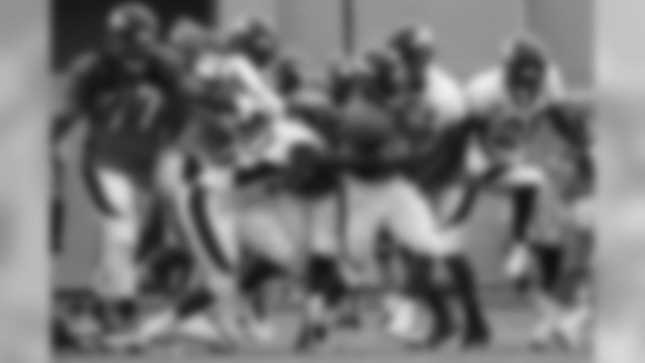 Running back De'Angelo Henderson Sr. (33) is swarmed by defenders at the fifth day of training camp on August 1, 2018, at UCHealth Training Center.