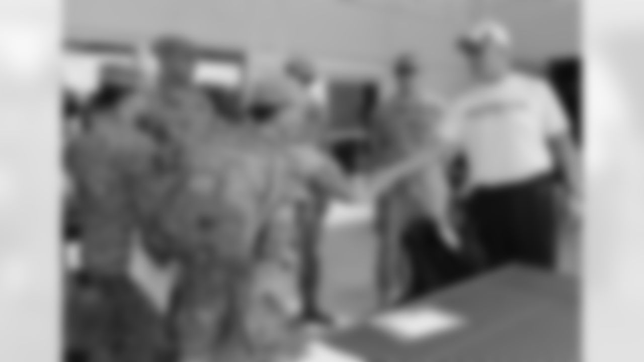 EVP of Football Ops Broncos John Elway shakes hands with soldiers from Fort Carson.