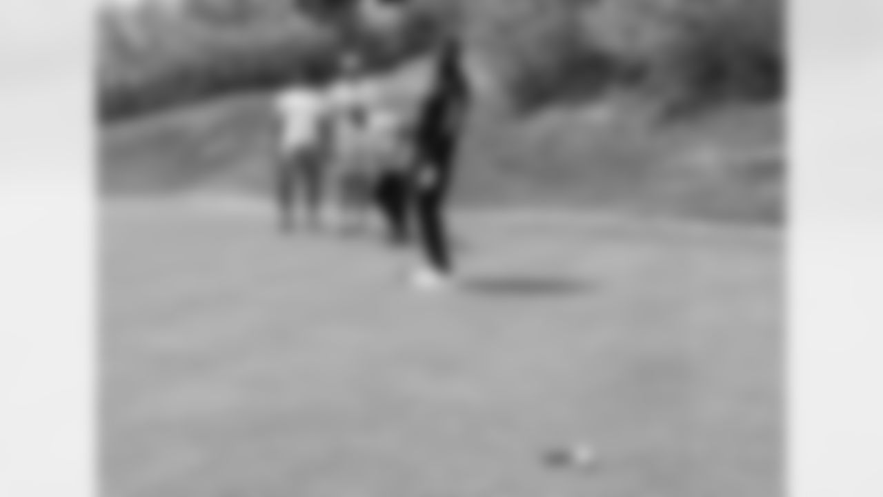 Demaryius Thomas, Paxton Lynch and Isaiah McKenzie watch as Emmanuel Sanders' putt just narrowly lips out at the Broncos' team golf outing on May 22, 2017 at Sanctuary Golf Course.