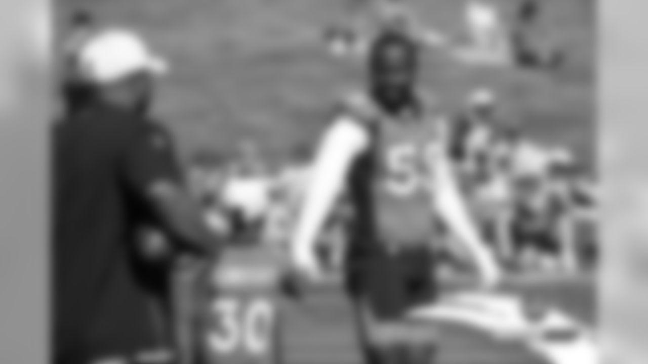 Von Miller greets Running Backs Coach Curtis Modkins and his son during practice on Day 2 of training camp on July 19, 2019.