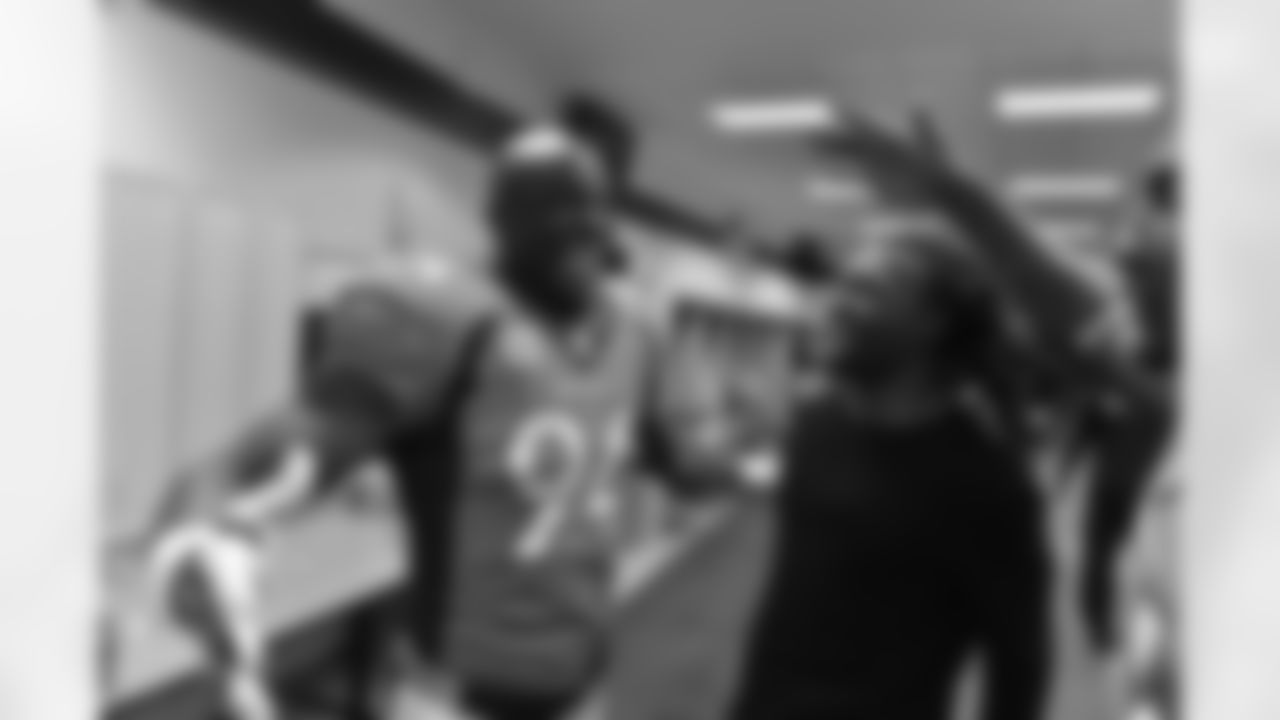 Denver Broncos DeMarcus Ware (94) is all smiles postgame in the locker room as he celebrates with teammates after he recovered a Cincinnati Bengals quarterback AJ McCarron (5) fumble to secure an overtime win over the Bengals 20-17 in the NFL game in Denver, Colo. December 28, 2015. (© Eric Lars Bakke/ Denver Broncos)