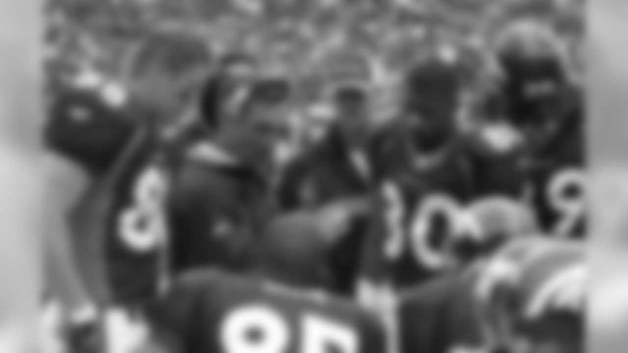 Mike Shanahan discusses a strategy with his players along the bench area during a 2004 game against the Falcons at Invesco Field at Mile High in Denver, CO. ©Brett Wilhelm/Rich Clarkson and Associates, LLC