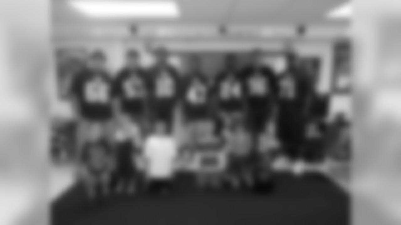 The group of Broncos players who served at The Crossing pose for a photo with some young Broncos fans.