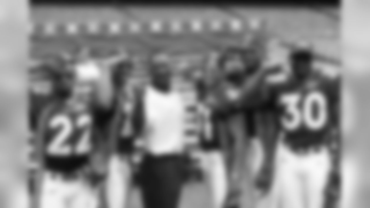 Denver Broncos running backs Vaughn Hebron (22) Howard Griffith (29), coach Bobby Turner, running backs Derek Loville (31), Anthony Lynn (37) and Hall of Fame running back Terrell Davis (30) give Mile High Salutes as they pose for a photo during the NFL Super Bowl 32 Media Day, Tuesday, Jan. 20, 1998, in San Diego. They defeated the Green Bay Packers 31-24. (Kevin Terrell via AP)