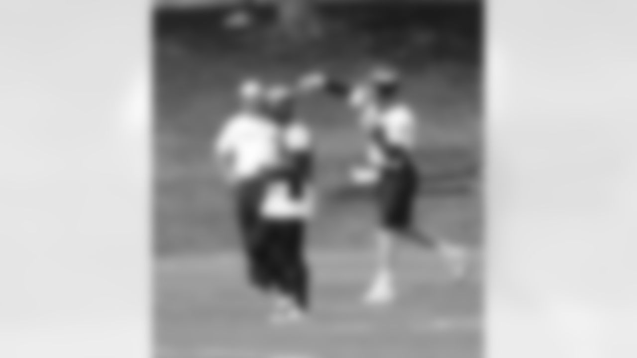 Manning fires a pass as QB Coach Adam Gase looks on.