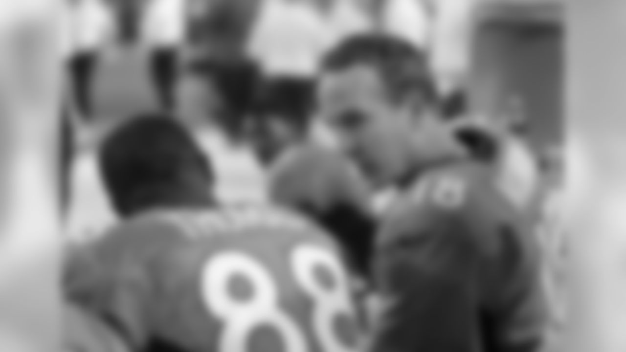 Manning and Thomas talk on the bench.
