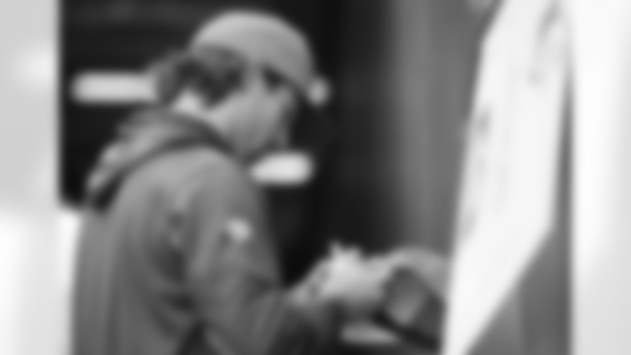 Decker signs an autograph before kickoff Sunday against the Chiefs.