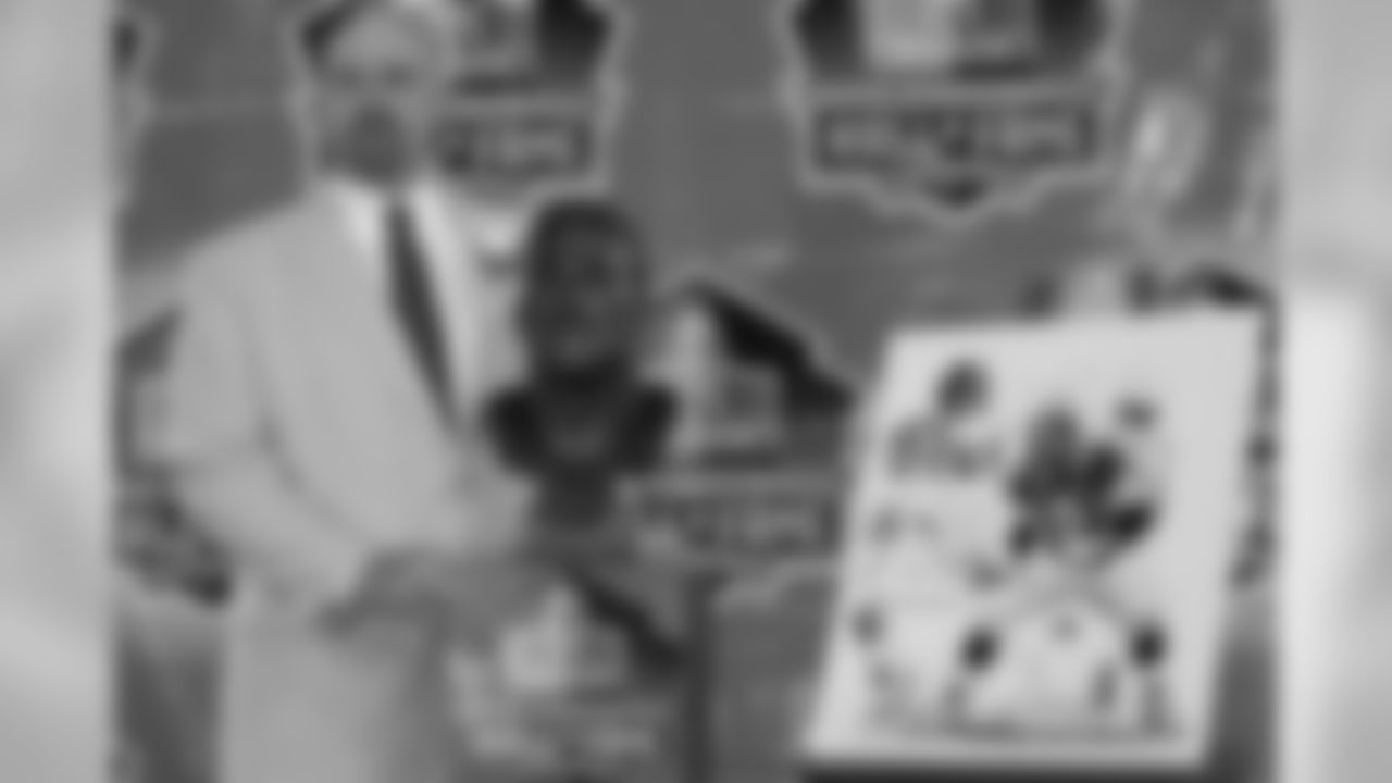 Zimmerman poses by his bust and picture.