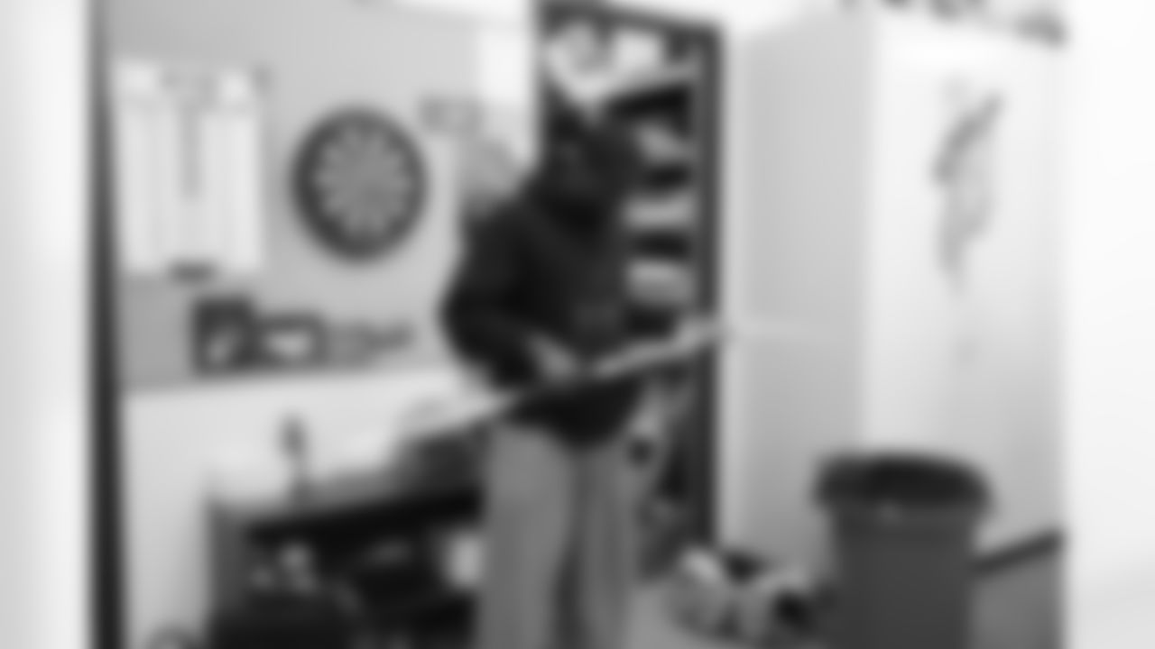 WR Gerell Robinson plays with a hockey stick while waiting his turn in the equipment room.