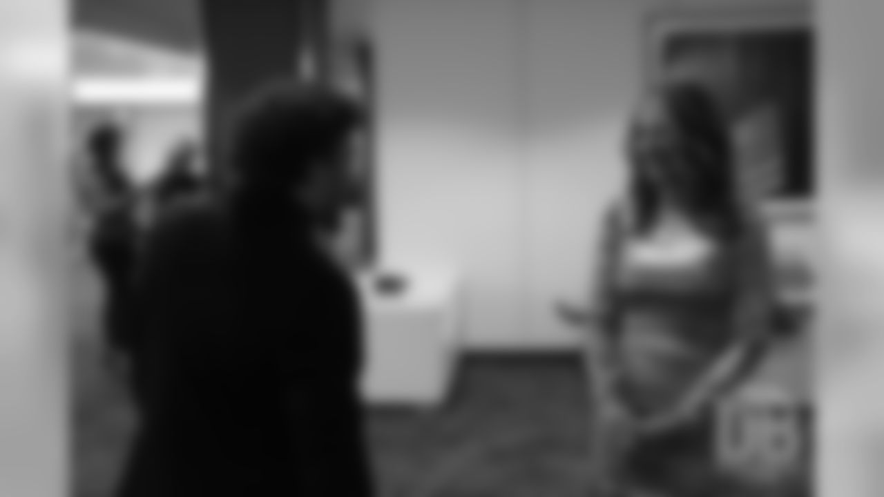 Phillip Lindsay greets Beth Bowlen Wallace before she awaits the knock on the door announcing the Pro Football Hall of Fame's selection of Pat Bowlen for enshrinement in the Class of 2019 on February 2, 2019.