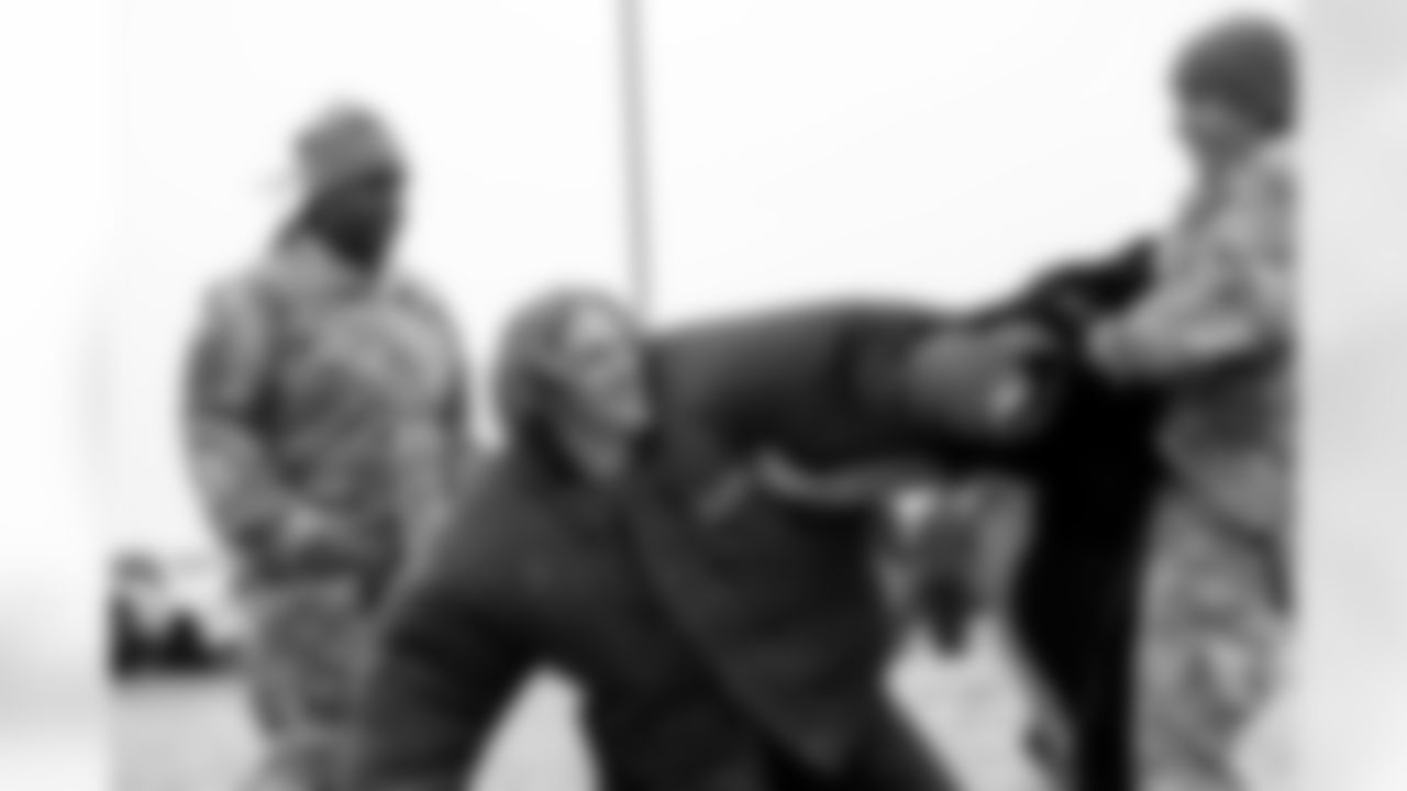 Andrew Beck, clad in a protective training suit, smiles as an attack dog is pulled off of him during the Salute to Service Caravan presented by USAA at Buckley Space Force Base in Aurora, Colorado on November 2, 2021. (Photo by Ben Swanson)