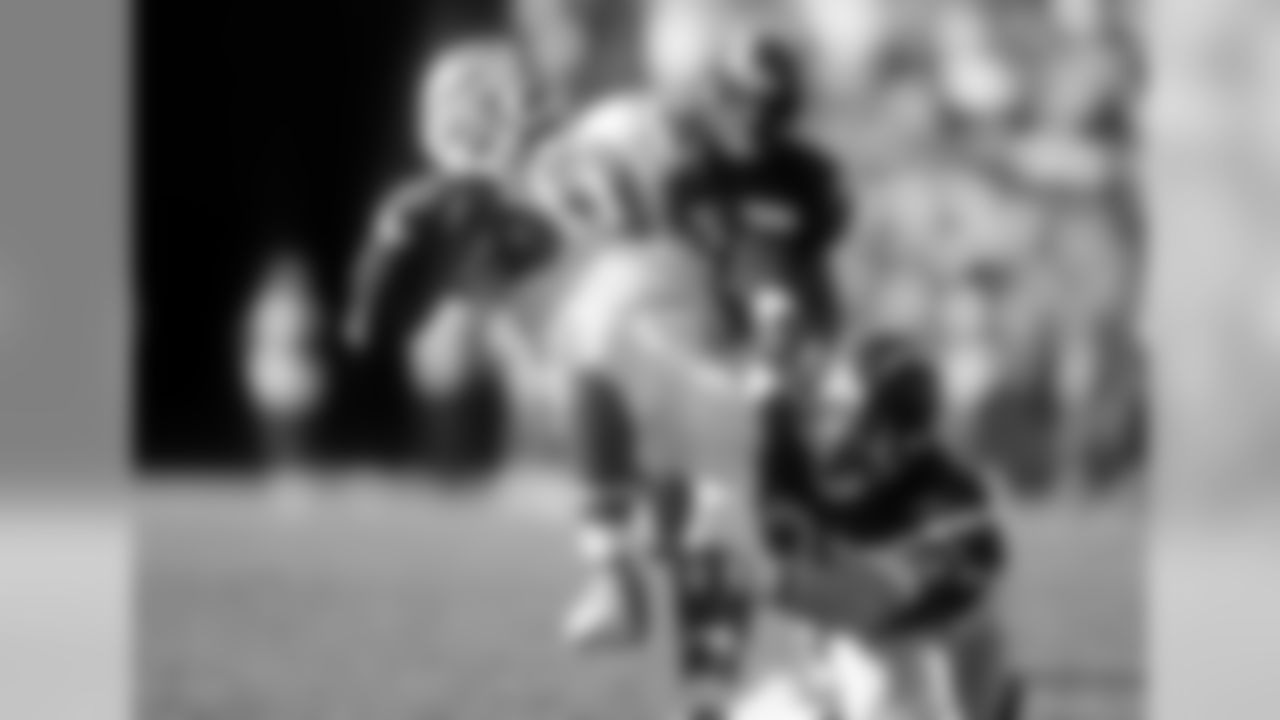 Terrell Davis tries to slip out of a tackle by Chargers safety Rodney Harrison.