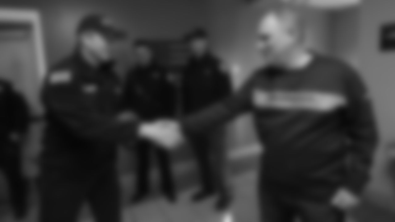 Head Coach Vic Fangio gives an autographed football to members of Aurora Fire Rescue during a visit for Random Acts of Kindness Week on February 20, 2019.