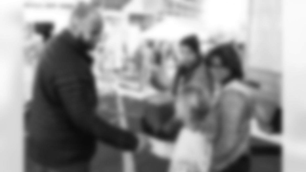 Gino Gradkowski meets a young fan during the Denver Rescue Mission's Thanksgiving Turkey in a Box distribution on Nov. 20, 2018