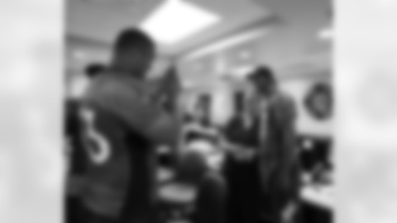Ben Garland takes a photo of Eric Decker with a hospital staff member.