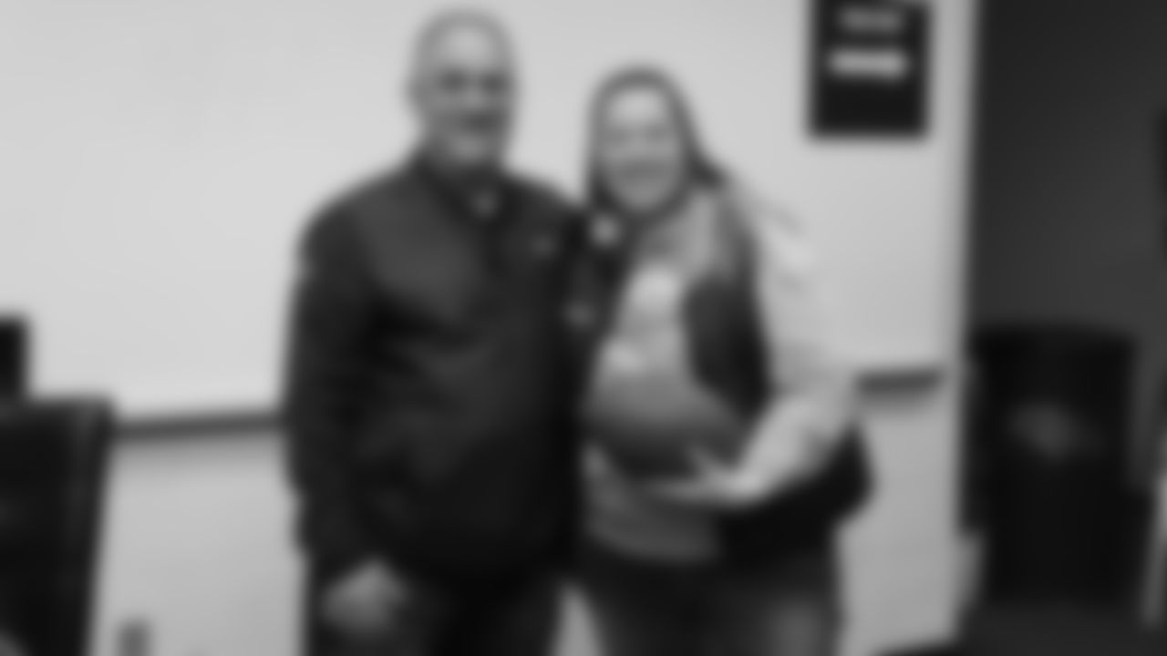 Head Coach Vic Fangio poses for a photo with a raffle winner at a meet-and-greet visit with team employees at Broncos Stadium at Mile High on March 19, 2019.