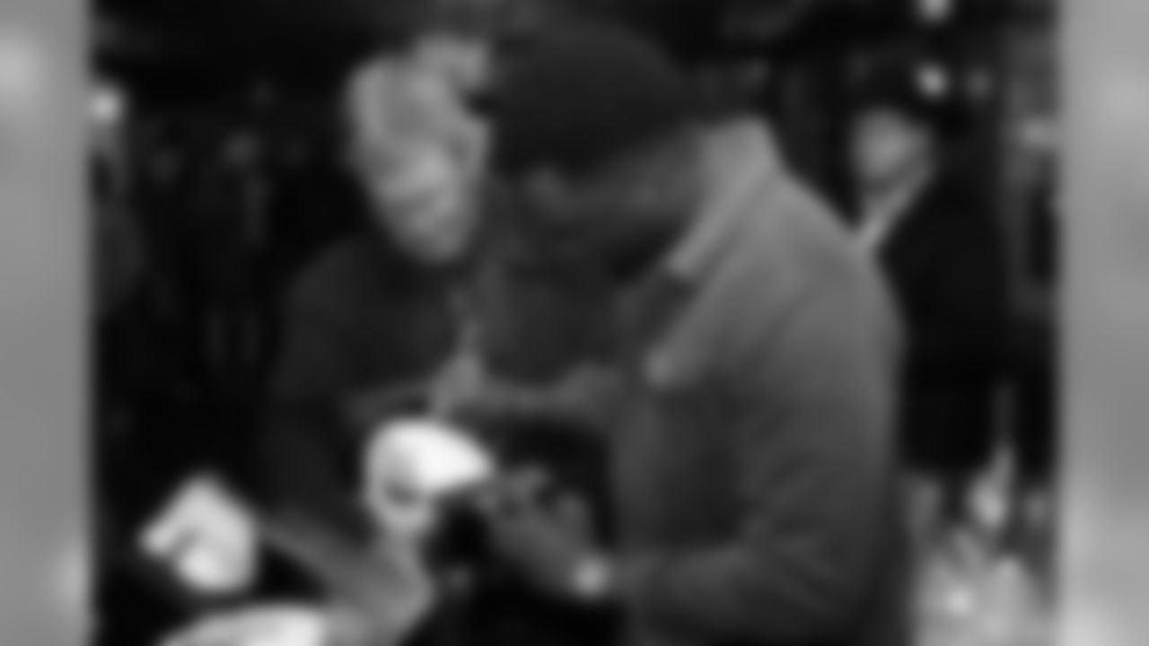 Brandon Marshall signs a football during Von's Vision at Mile High Station in Denver on November 5, 2018.