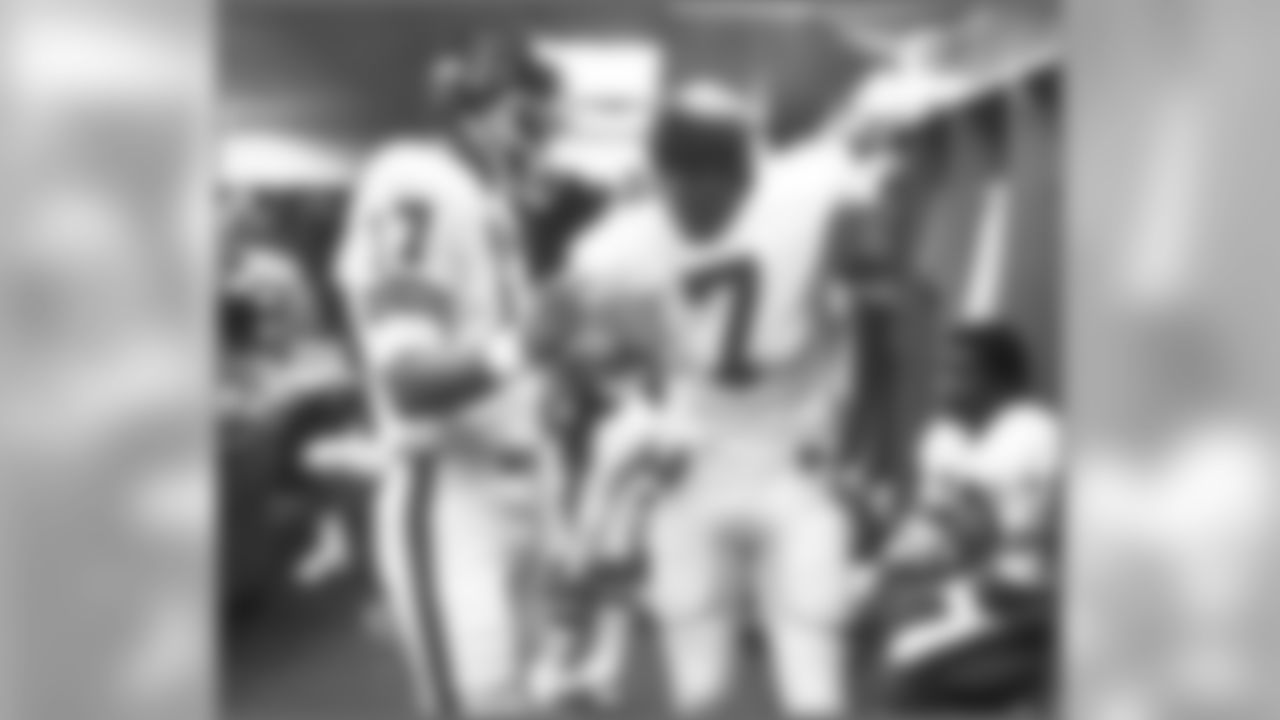 Veteran quarterback Steve DeBerg gives Elway some advice before a 1983 game.