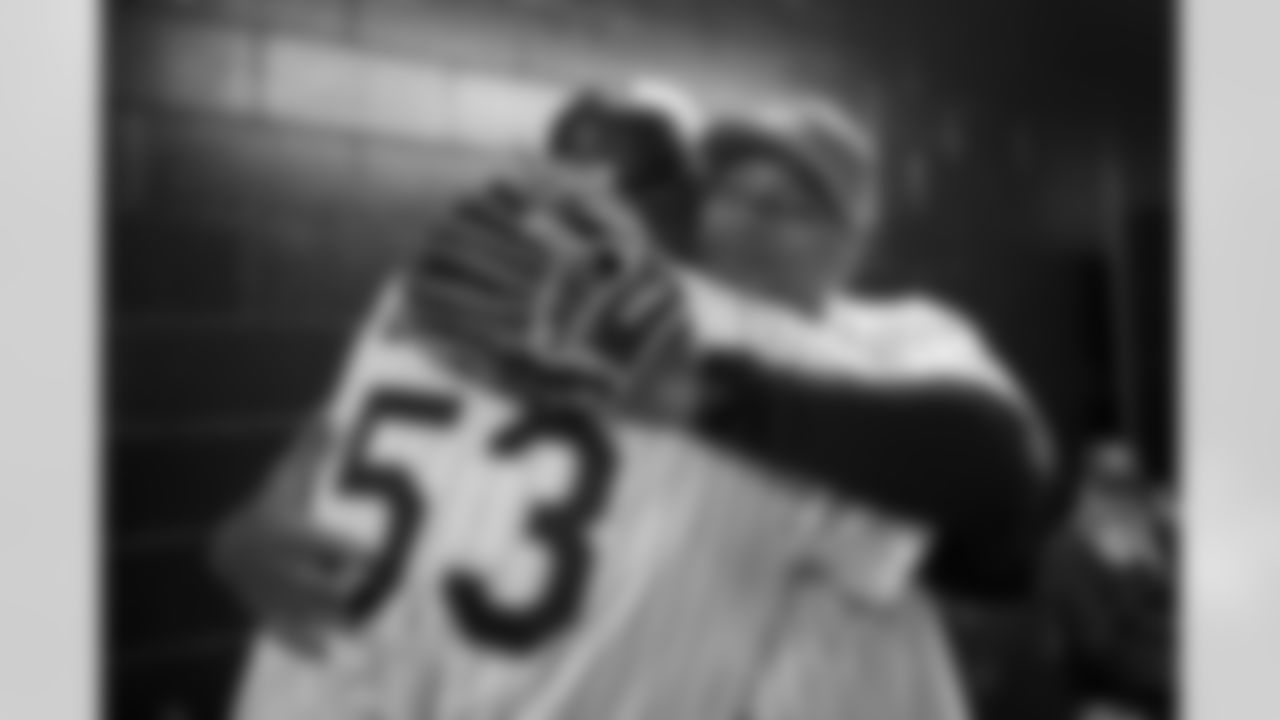 Russell Wilson hugs Rockies first base coach Ron Gideon during his visit to the Colorado Rockies' Opening Day game at Coors Field in Denver, Colorado on April 8, 2022. (Photo by Ben Swanson)