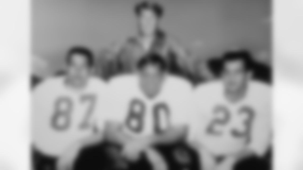 Coach Frank Filchock with his all-league trio, left to right, kneeling: receiver Lionel Taylor, defensive tackle Bud Mcfadin and safety Austin Gonsoulin.