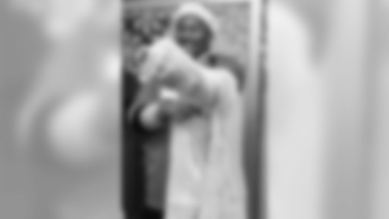 Bradley Chubb puts on a gown during a Build-A-Bear distribution at Children's Hospital Colorado in Aurora on December 17, 2018.