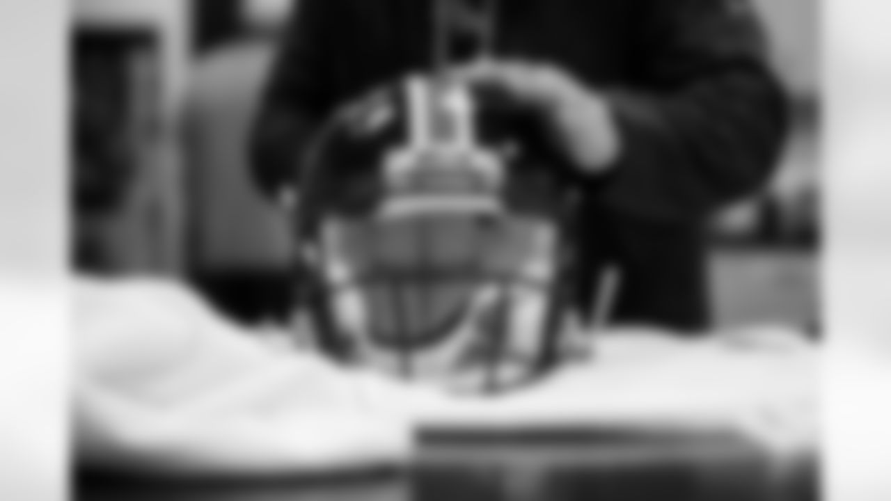 Members of the equipment staff place Color Rush decals on players' helmets at UCHealth Training Center in Englewood, Colorado on November 9, 2021. (Photo by Ben Swanson)