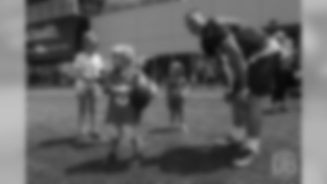 quarterback Chad Kelly (6) smiles as he hangs out with three children from Children's Hospital Colorado's burn unit after the final day of OTAs on June 7, 2018 at UCHealth Training Center. The young boy with the football had noticed the team's turf crew driving a large lawnmower as he and Kelly played catch
