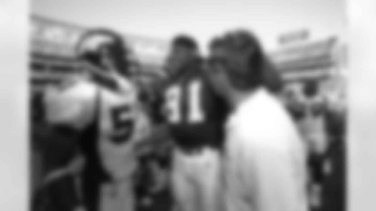 Former Broncos teammate Neil Smith, now of the San Diego Chargers, greets John Mobley and former coach Mike Shanahan after a game against the Chargers at Qualcomm Stadium in San Diego, CA on October 8, 2000.