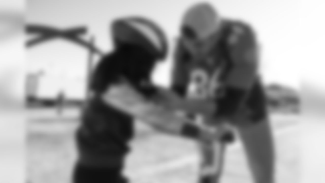 Tim Semisch adjusts a helmet during a bike distribution at Green Valley Elementary School in Denver on December 18, 2018.