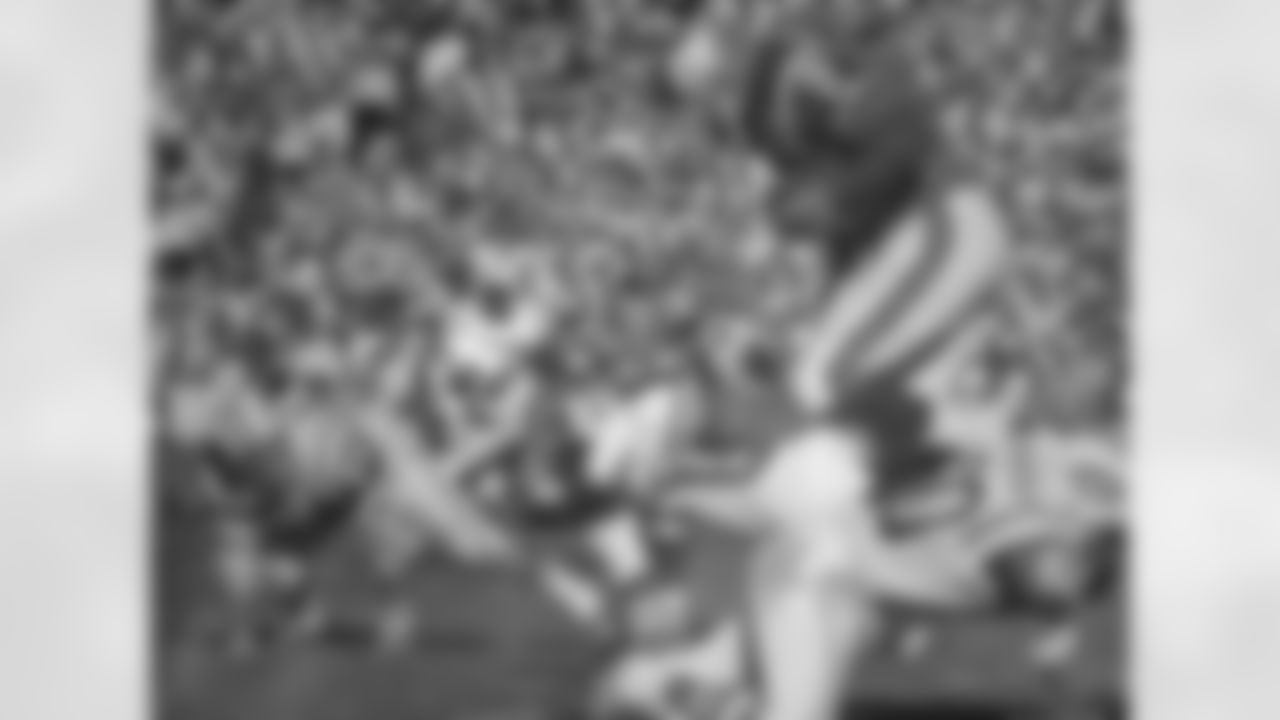 The white-horse helmet with the lone white stripe lasted through the 1965 season, even as the jerseys changed with a much wider shoulder stripe. Here, fullback Cookie Gilchrist leaps over a Jets tackler during an October 3, 1965 win (16-13) at Bears Stadium in Denver.