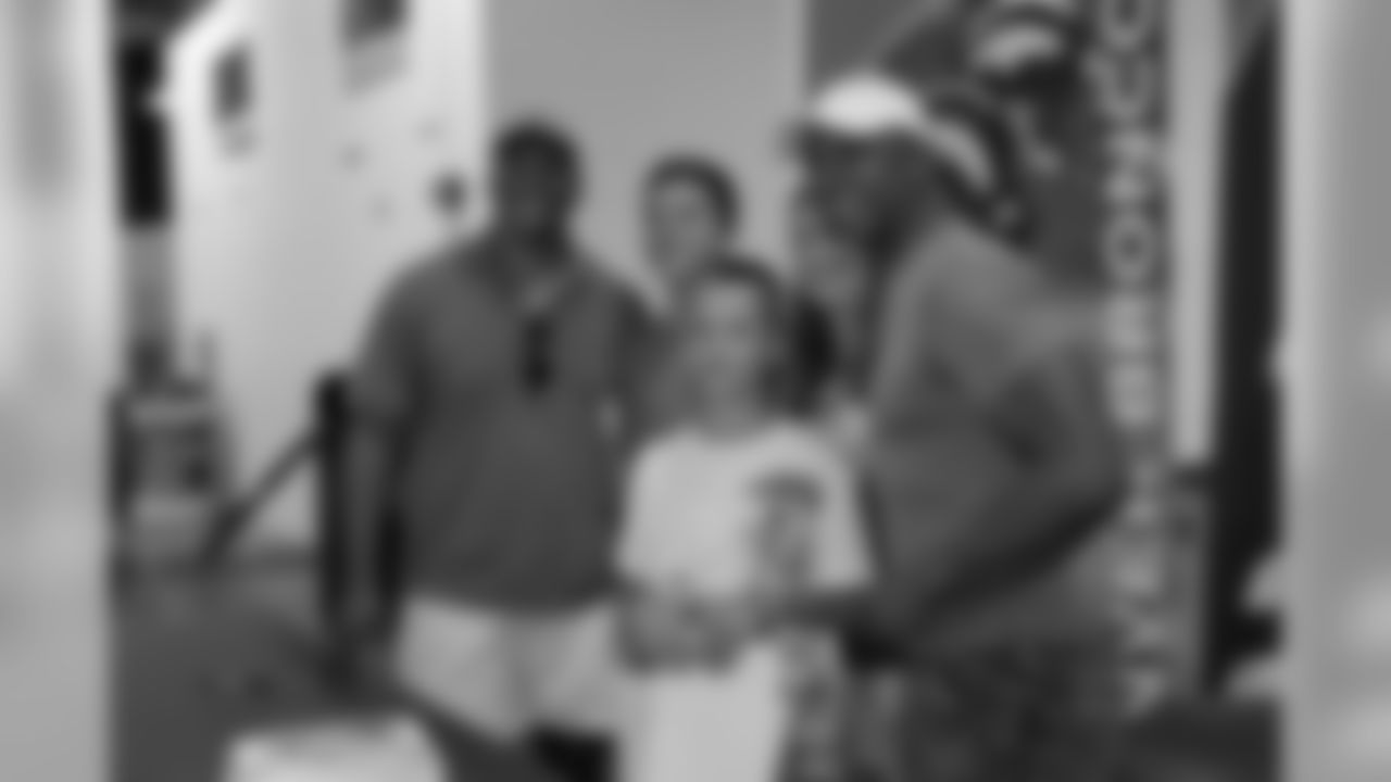 Broncos alumni Vance Johnson and Gene Lang pose for photos with Broncos Bunch members as part of Be a Champion in the Community week.