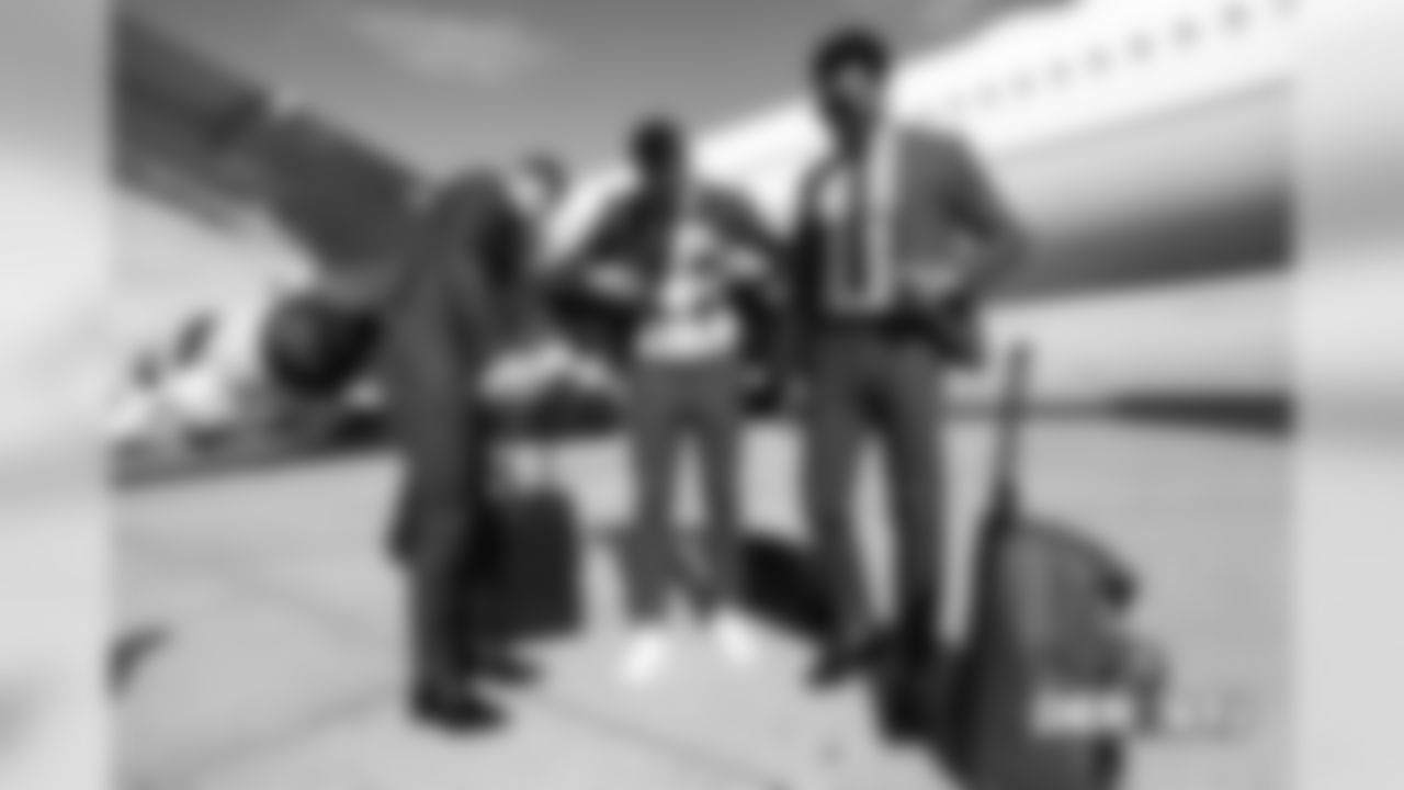 Jeff Heuerman, Brandon McManus and Demaryius Thomas prepare for a group photo on the tarmac at Denver International Airport during the team's travel for their Week 5 game against the New York Jets on October 6, 2018.